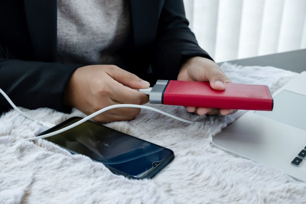 Man staying safe by backing up mobile device to hard drive.